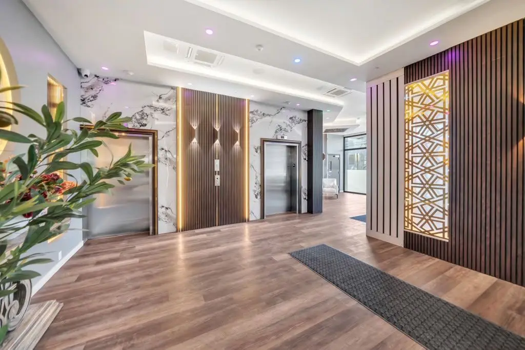 Building lobby with elevators, wood slat panels and indoor plants